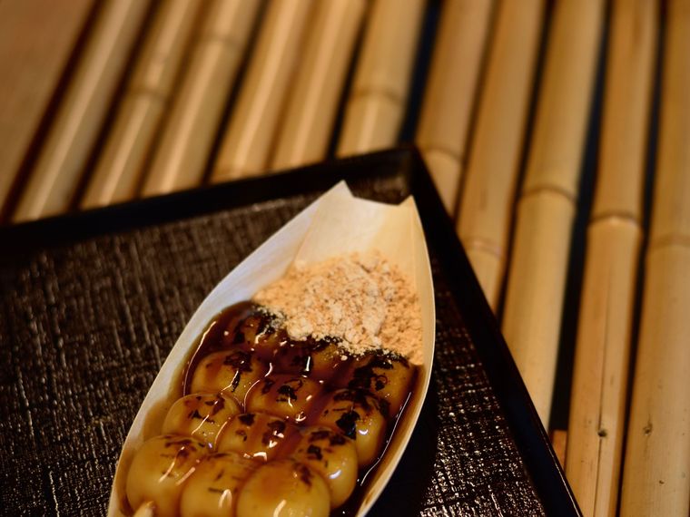 Skewered rice dumplings served in a paper boat