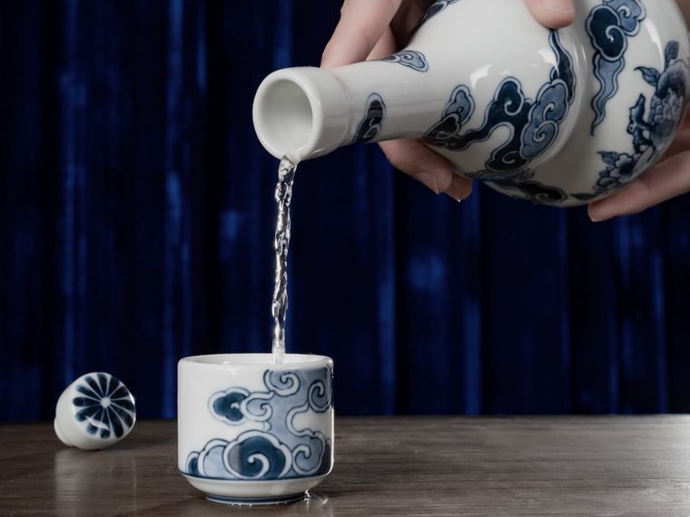 Sake poured from a ceramic flask into a small cup